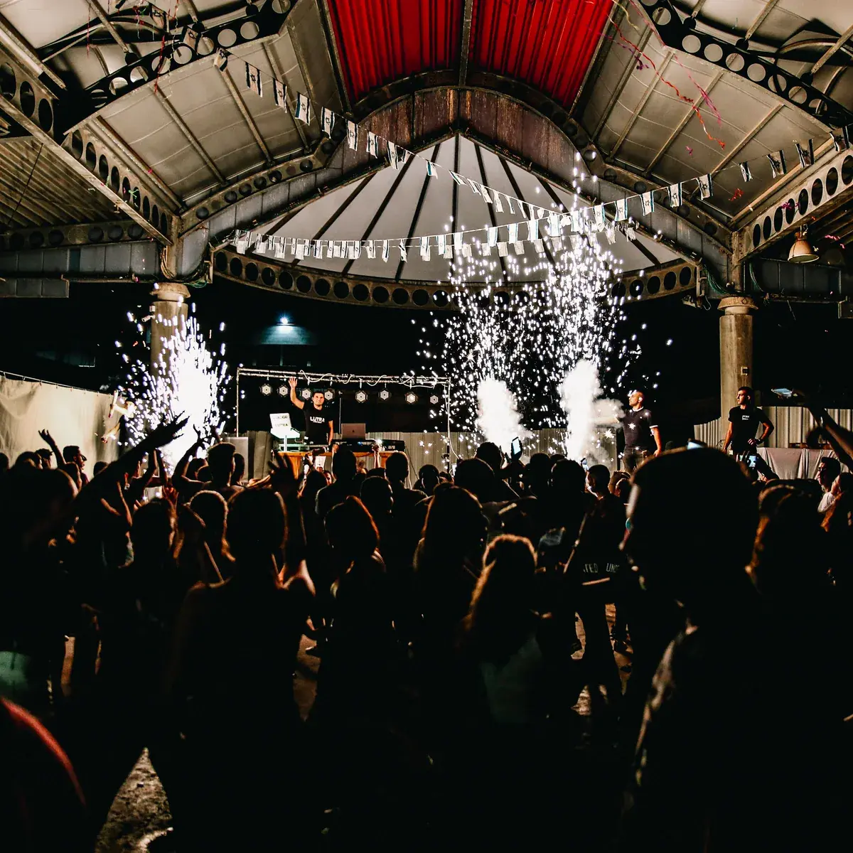 Vertical smoke jets firing over a packed dancefloor